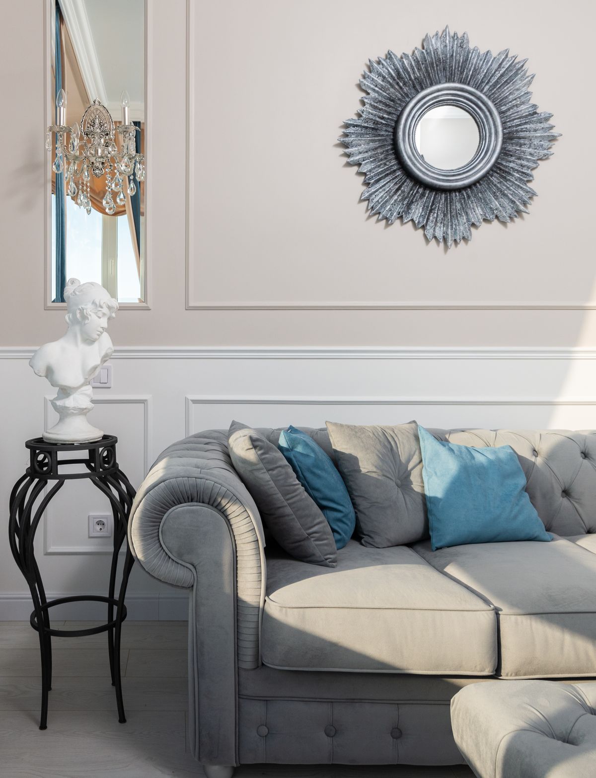 Living room with round wall mirror above sofa illustrating feng shui mirror placement and active chi zones Creative living room interior with decorative bust and round mirror above sofa illustrating feng shui mirror placement rules in a living area