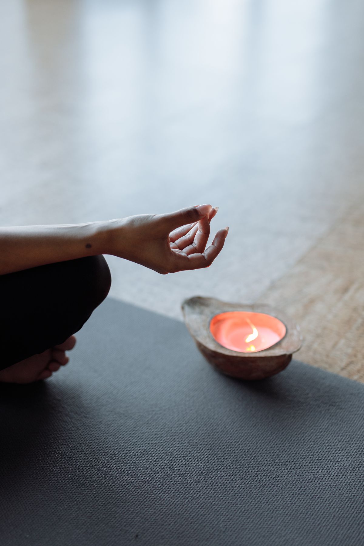 Serene meditation space with hand mudra and candlelight suggesting reflective calm