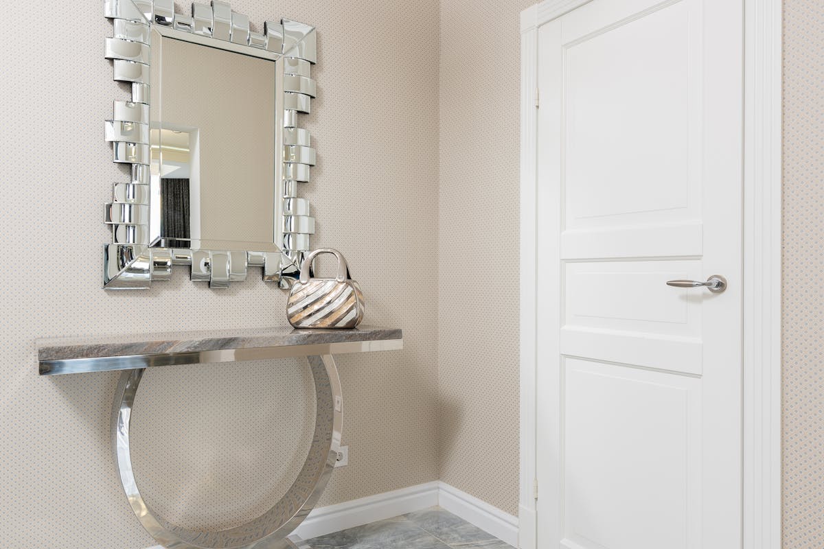 Entryway console table with a decorative mirror above it, illustrating entryway mirror ideas.