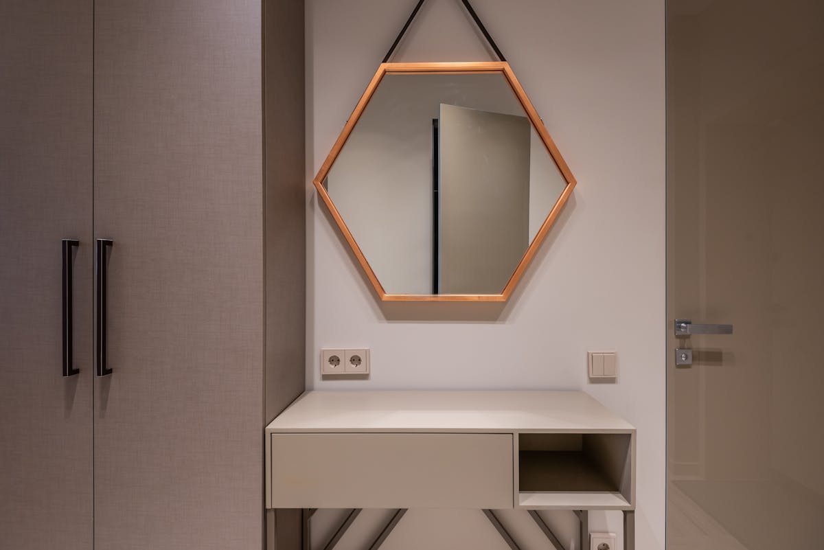 Mirror mounted above a cabinet illustrating the correct dresser mirror size and height Mirror hanging on the wall above a low cabinet showing how high to hang a dresser mirror