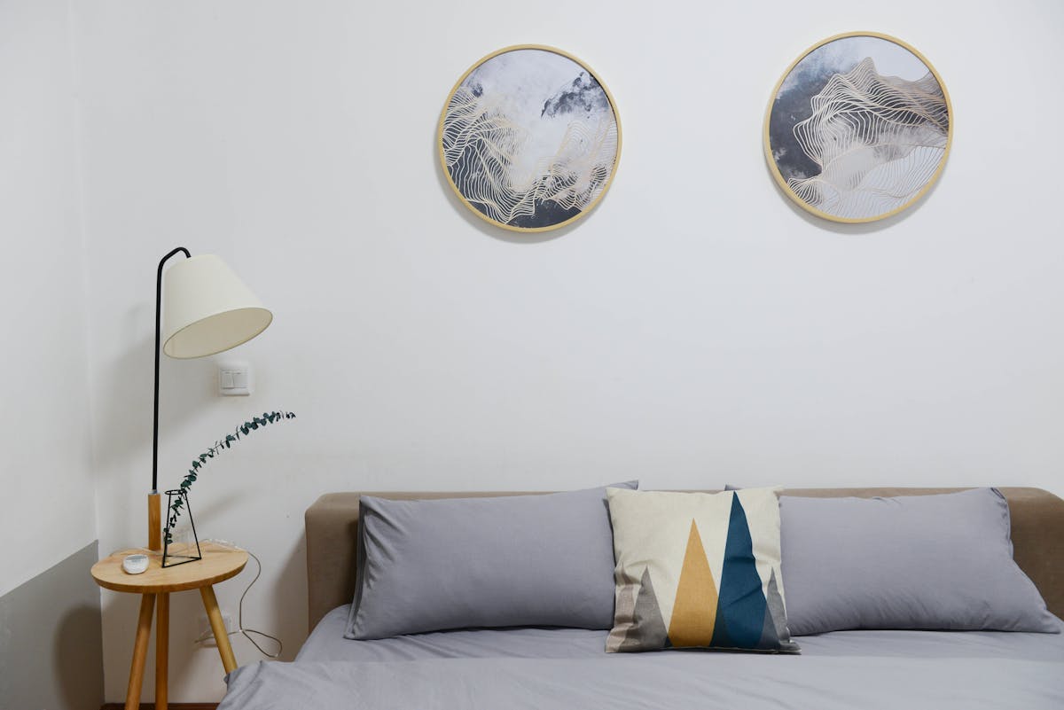 Bedroom focal wall above the bed illustrating where to start with bedroom wall decor Modern bedroom with minimalist abstract wall art above the bed, illustrating the focal wall in bedroom wall decor
