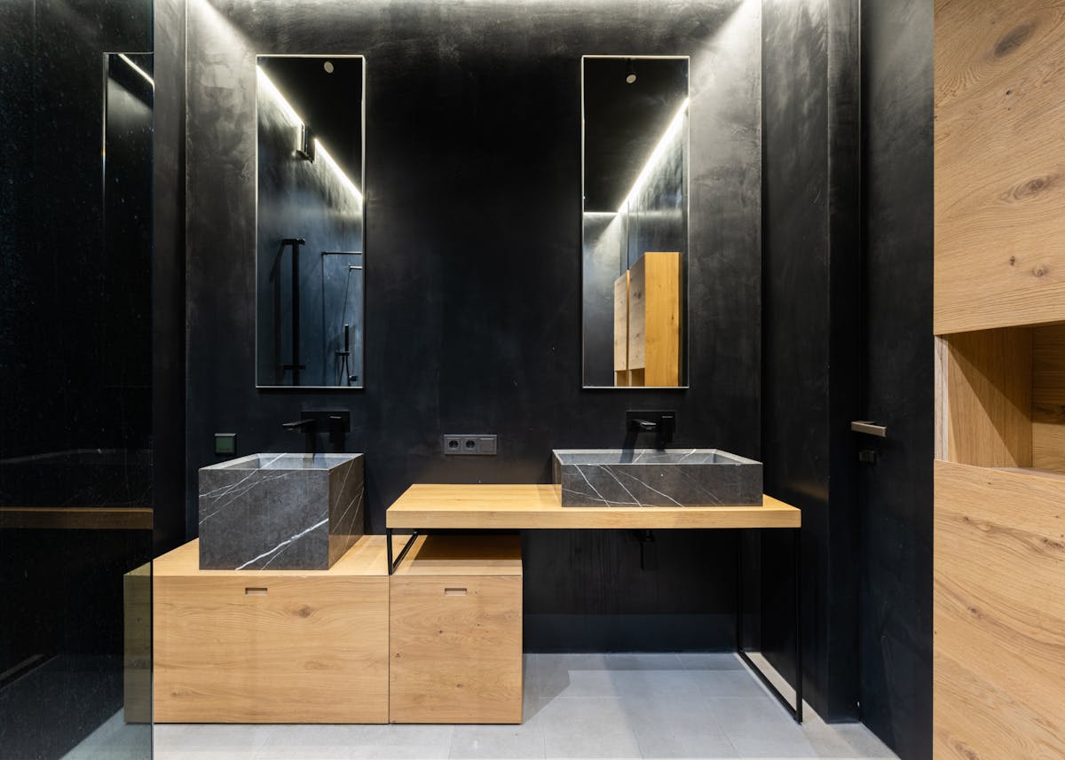 Mirrors against a dark wall illustrating the black mirrored wall contrast rule Modern washroom with mirrors against a dark wall, illustrating the contrast rule for black mirror decor