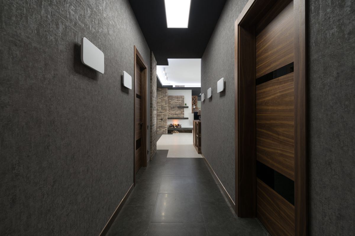 Long corridor with grey walls and doors leading to a bright room, illustrating the hallway mirror far-end question