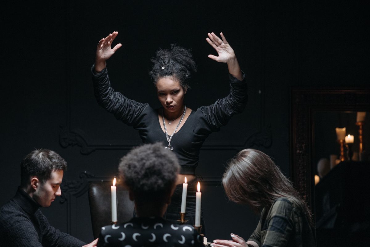Spiritual seance gathering with participants around a candlelit table creating a mysterious and atmospheric scene