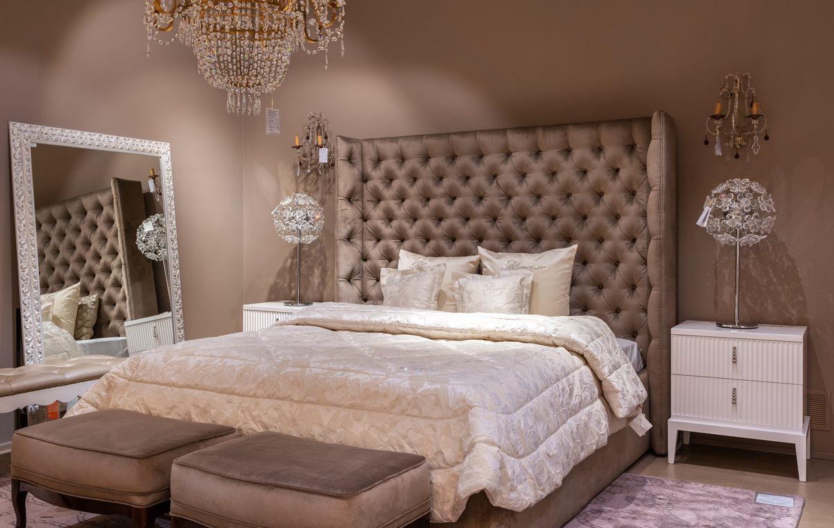 Bedroom with a framed mirror mounted on the wall beside the bed and nightstand showing correct mirror hanging height