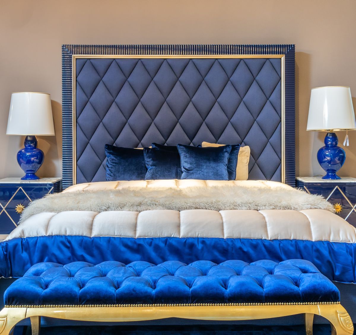 Bedroom with a bed and an upholstered bench acting as a buffer near the wall, illustrating a feng shui buffer cure