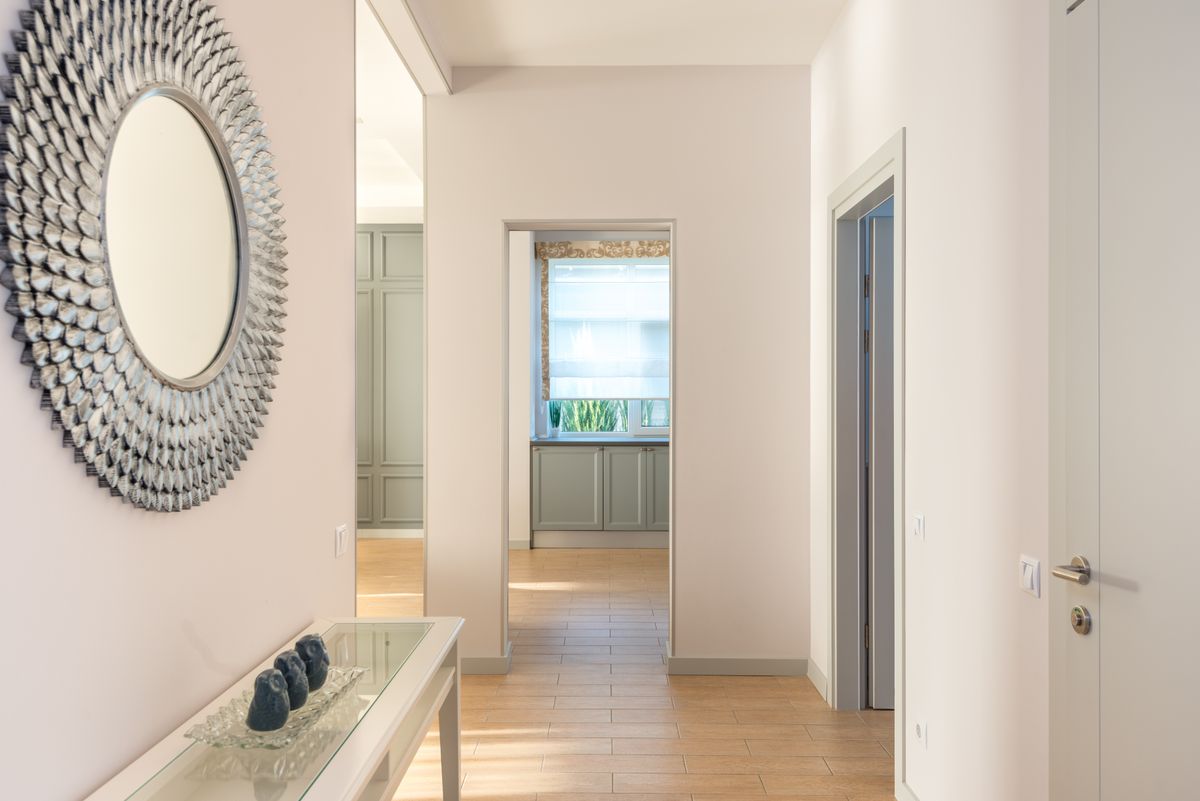 Minimalist hallway with wall art and natural light, showing what a hallway mirror should reflect