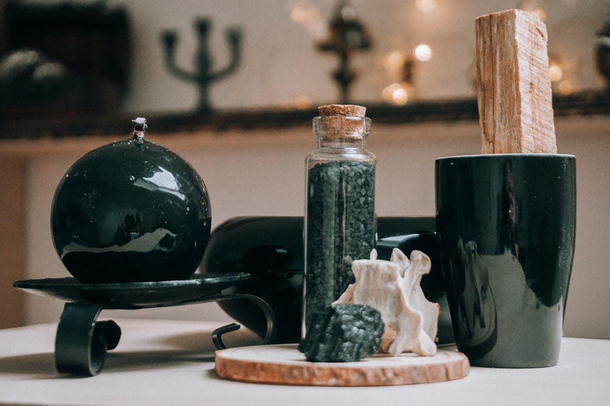 Black obsidian sphere and ritual items arranged on a wooden board for a divination and black mirror scrying practice