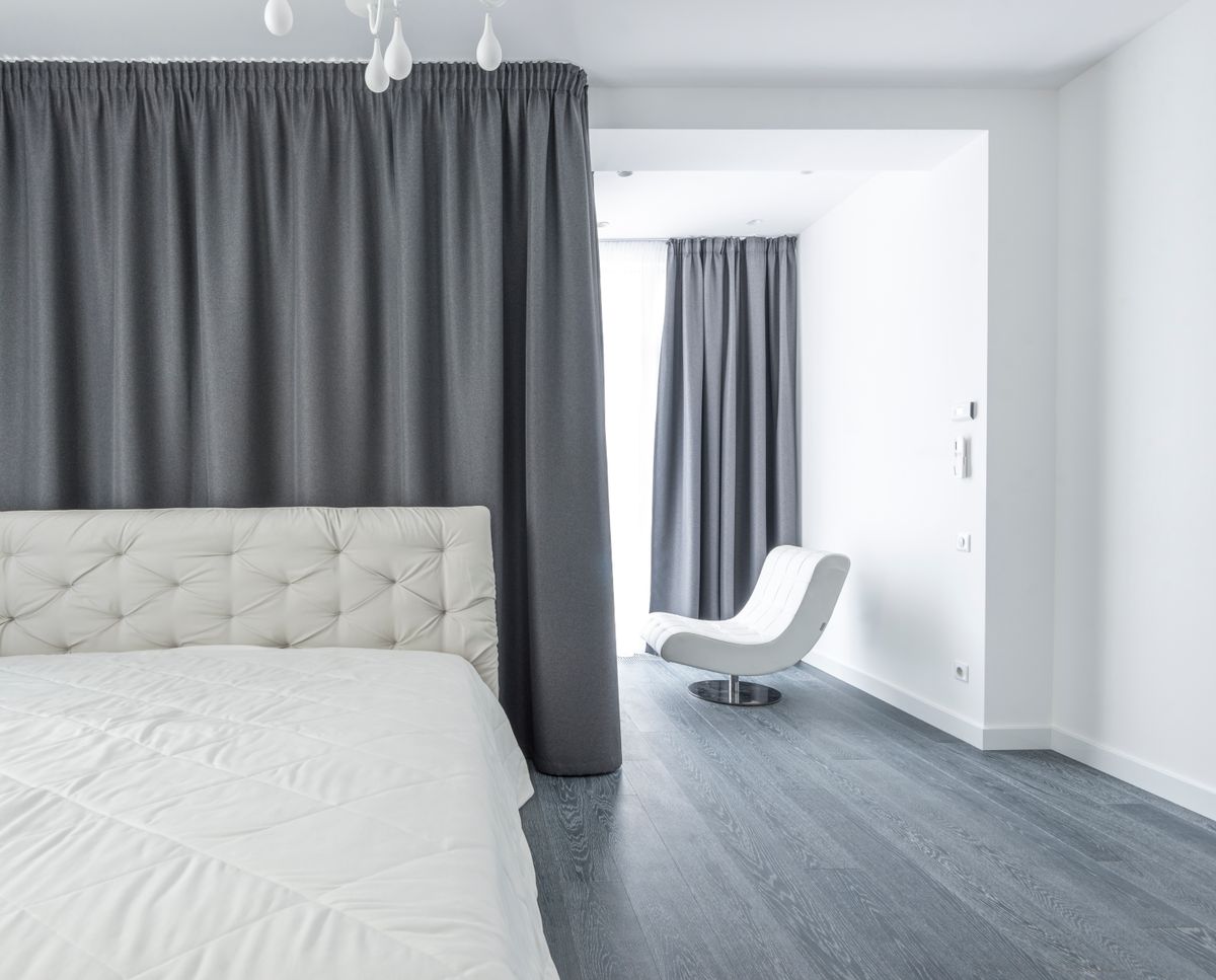 Modern bedroom with white bedding and soft grey curtains, illustrating the clarity of the feng shui Metal element