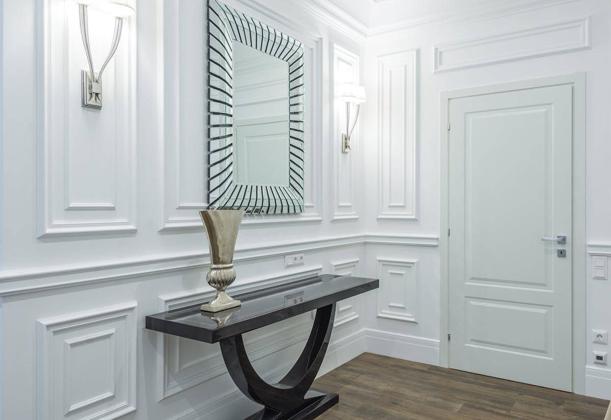 Sleek hallway mirror at eye level illustrating entryway mirror placement Sleek hallway with a mirror at eye level showing entryway mirror placement and height