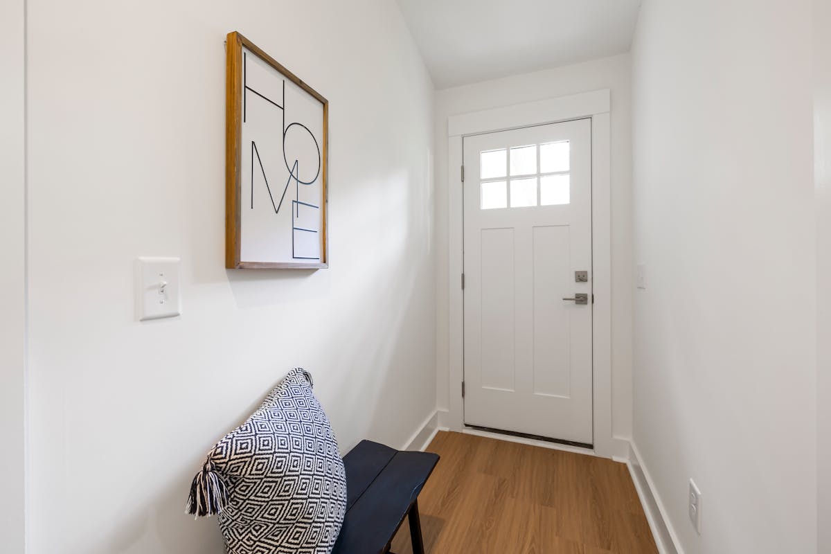 Bright entryway with a bench illustrating why an entryway bench with mirror combo works Bright minimalist hallway with a bench and decor, showing why an entryway bench with mirror works