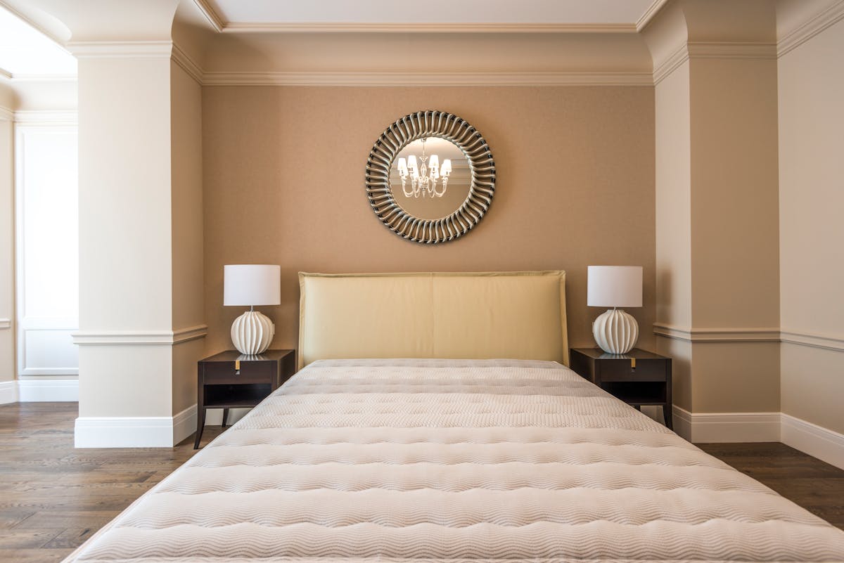 Bedroom with symmetrical bedside lamps and balanced decor on both sides of the bed illustrating paired mirrors over nightstands