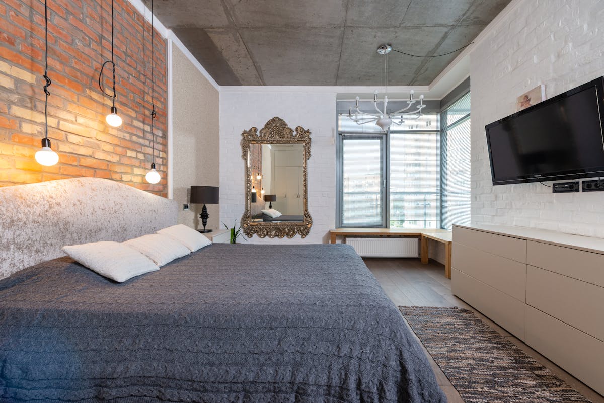 Large mirror hung above a bed showing how high a mirror should go above a headboard Large mirror on the wall above a king-size bed showing how high a mirror should go above a bed