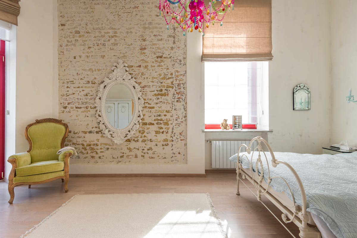 Elegant vintage bedroom with an ornate mirror reflecting warm chandelier light illustrating Feng Shui bedroom mirror placement guidance.