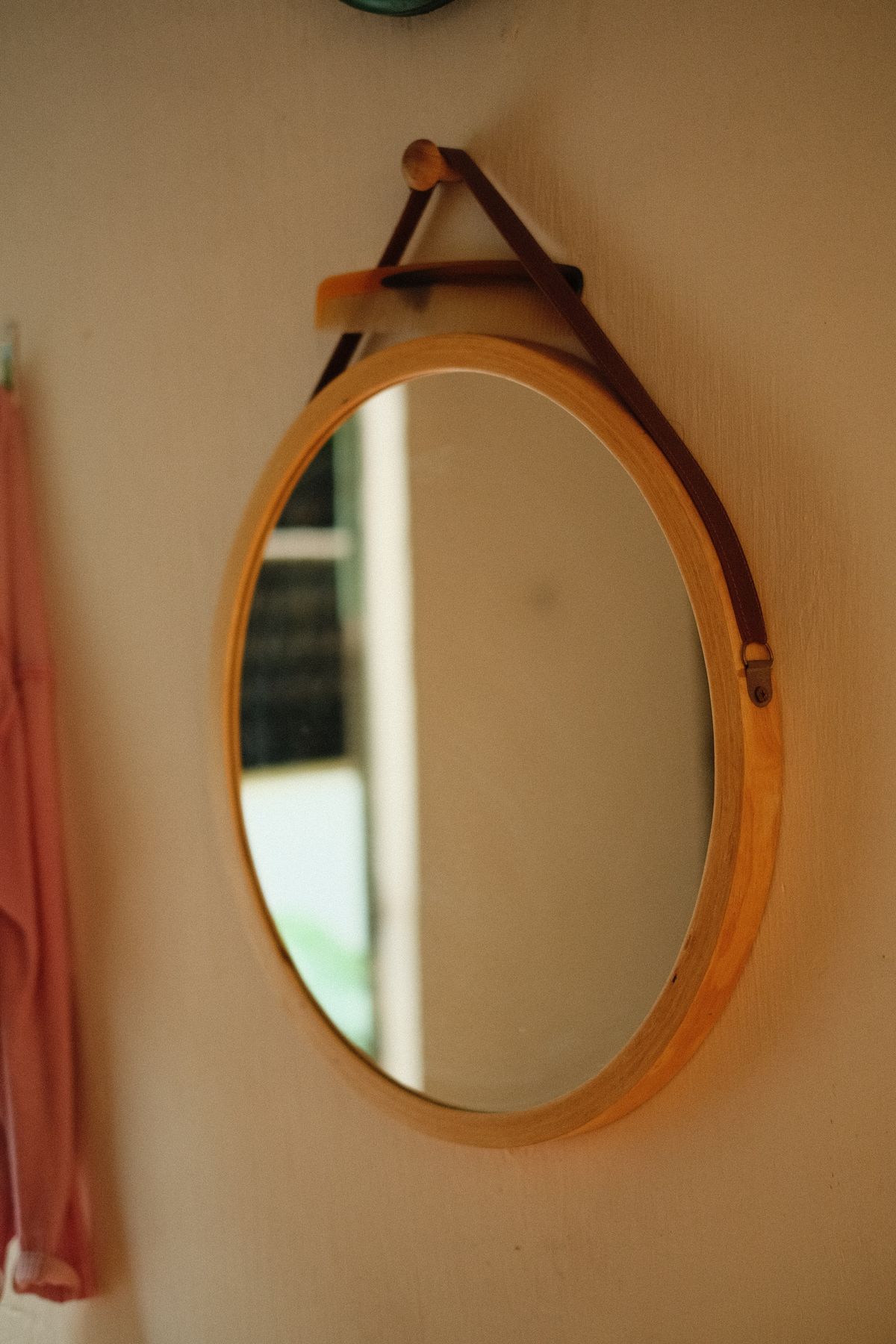 Wooden framed rectangular wall mirror in simple bright interior near window