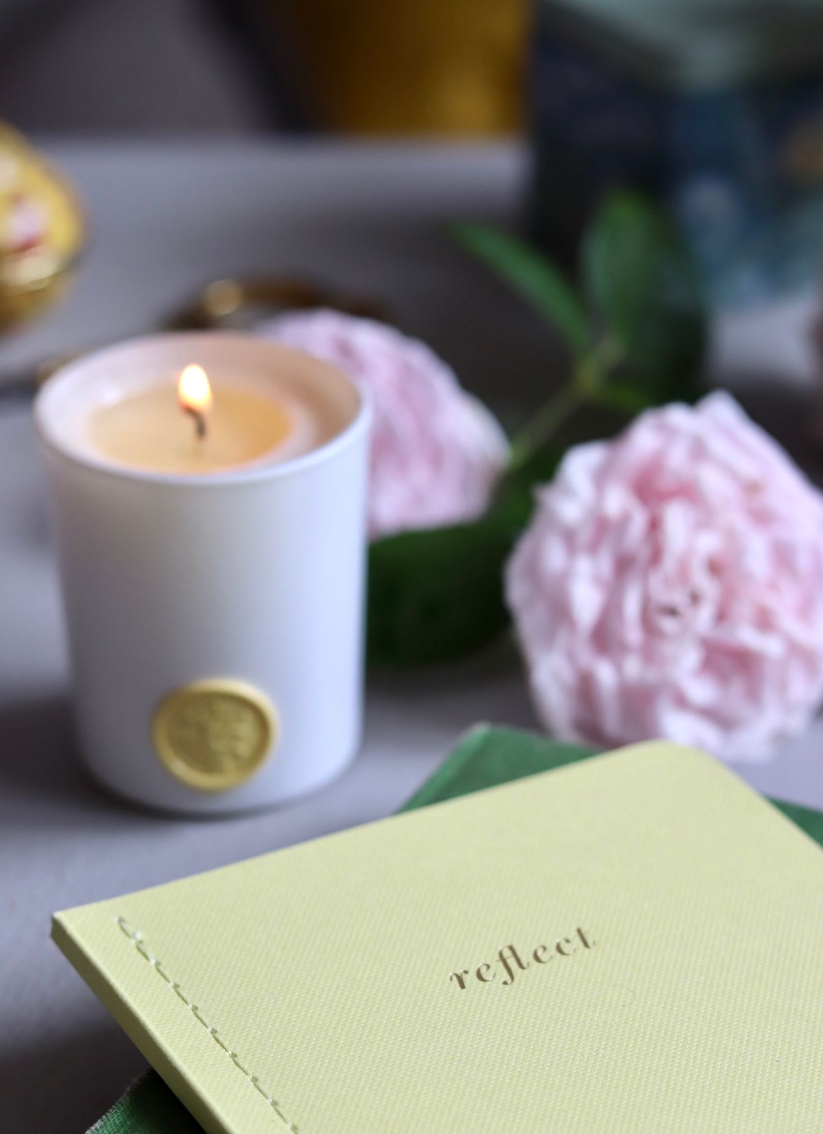 Candle notebook still life for journaling broken mirror dreams and emotional processing Lit candle with flowers and reflective notebook suggesting journaling after spiritual dreams