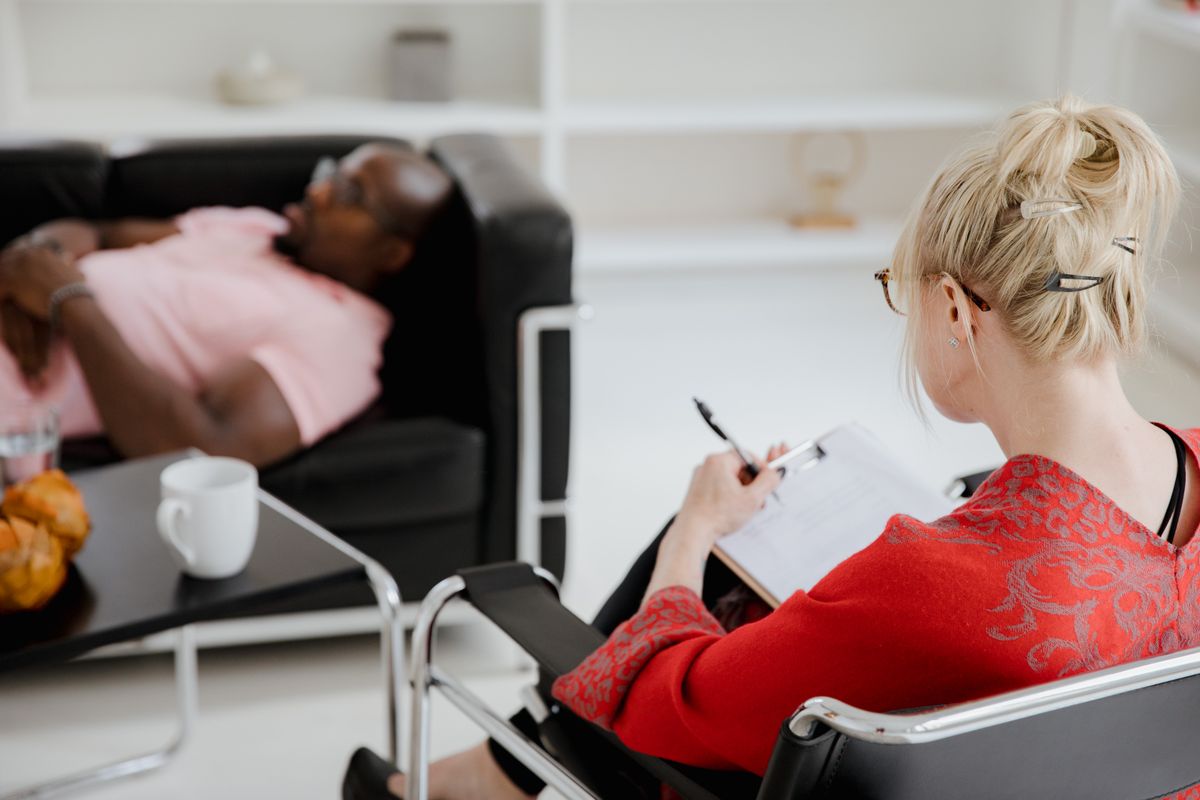 A therapist taking notes during a calm counselling session representing professional treatment for the fear of mirrors