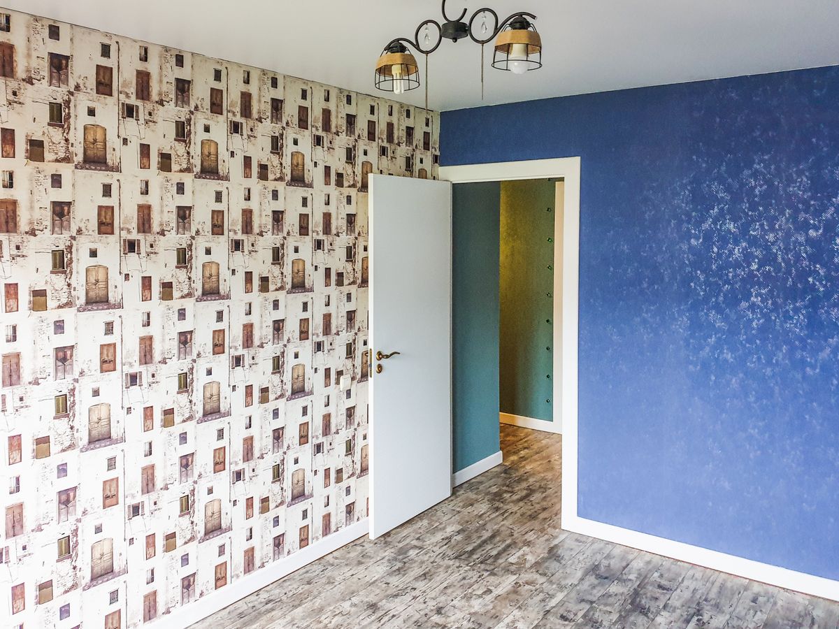 Modern living space with a blue patterned wallpaper feature wall, illustrating wallpaper as living room accent wall decor